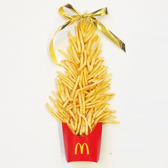 a bunch of french fries in a red container with a yellow ribbon tied around it