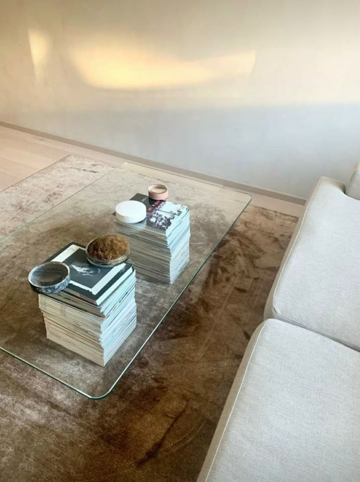 a glass coffee table with books on top