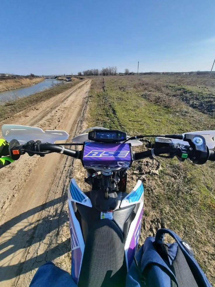 a motorcycle is parked on the side of a dirt road