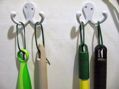 three different colored umbrellas hanging from hooks on a white wall next to each other