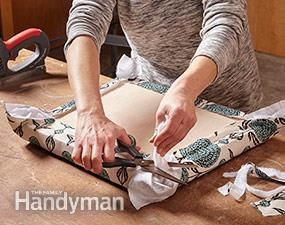 a woman is cutting fabric with scissors on the table in front of some crafting supplies