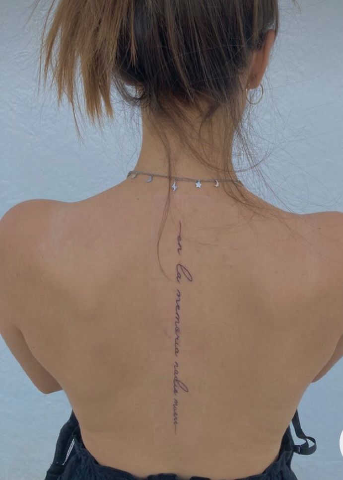 the back of a woman's neck with writing on it