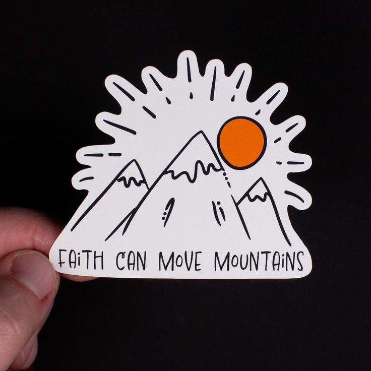 a hand holding up a sticker that says, earth can move mountains