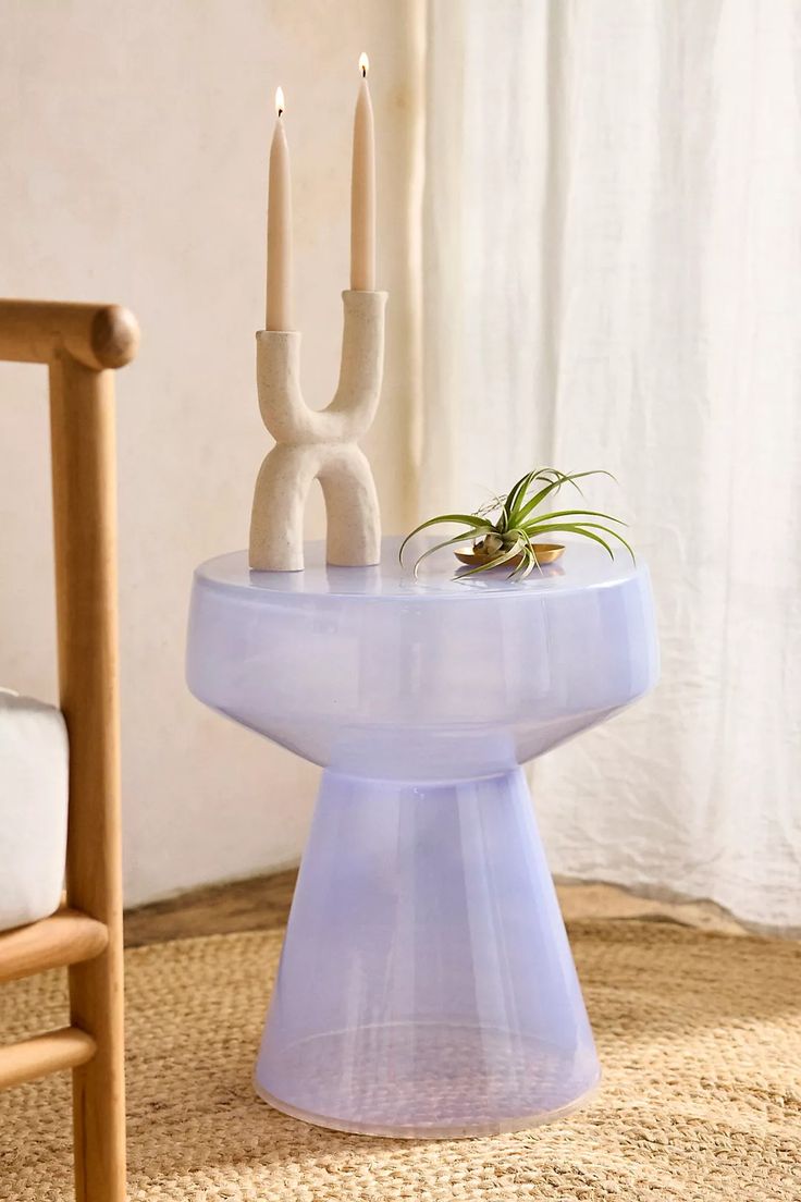 an air plant is sitting on top of a table with two candles in the background