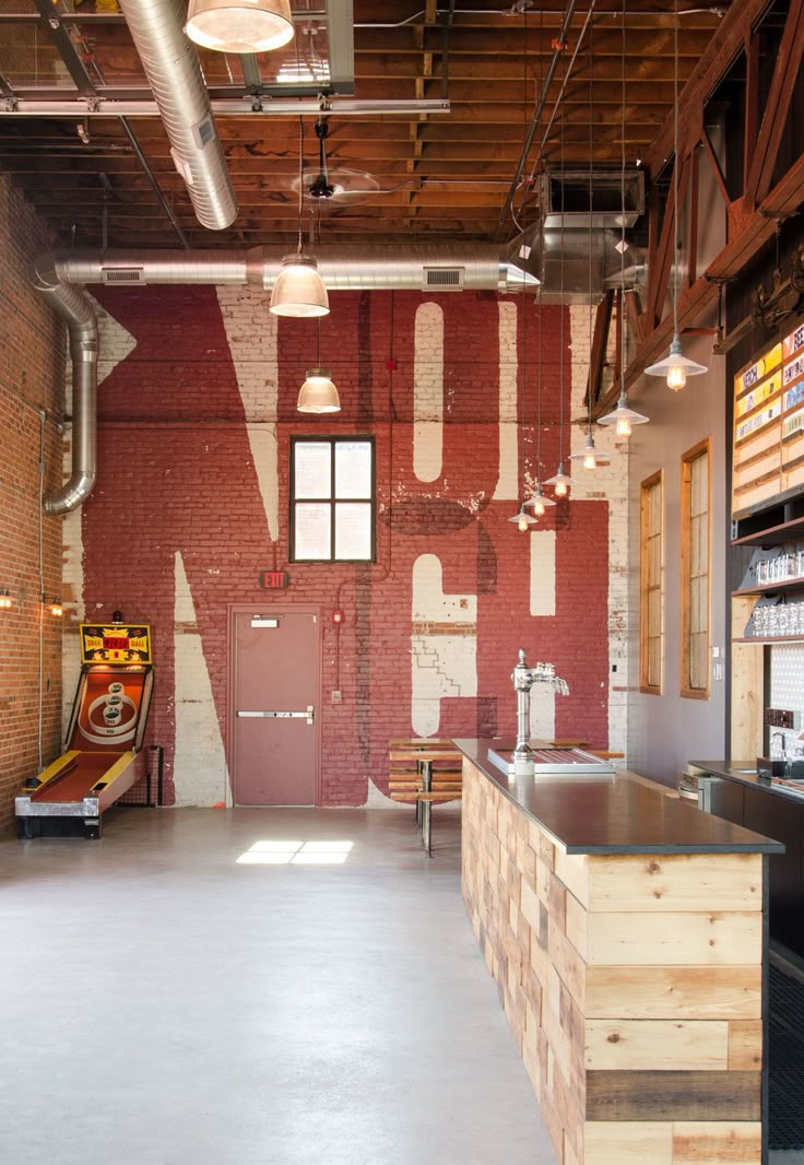 the inside of a restaurant with red brick walls and exposed ceilings, an open floor plan