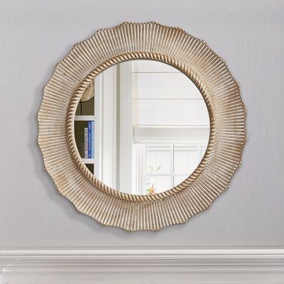 a round mirror hanging on the wall above a fireplace