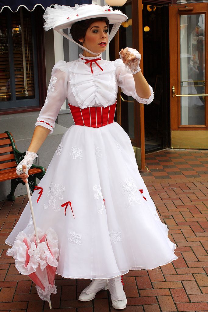 a woman in a white and red dress holding an umbrella