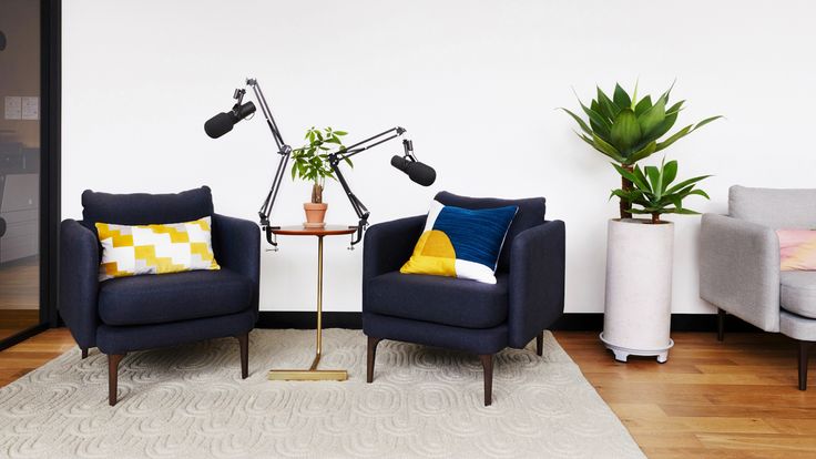 two blue chairs sitting next to each other on top of a hard wood floored floor