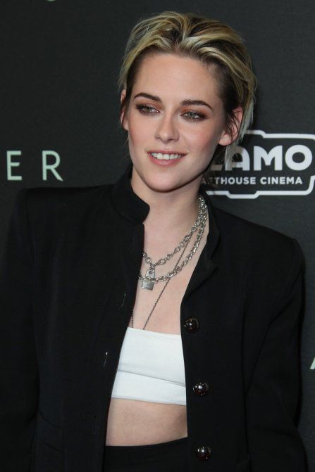 a woman wearing a black jacket and white top