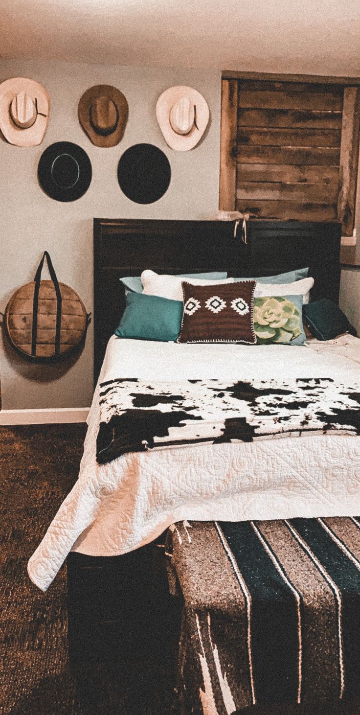 a bed sitting in a bedroom next to two wooden wall hangings with hats on them