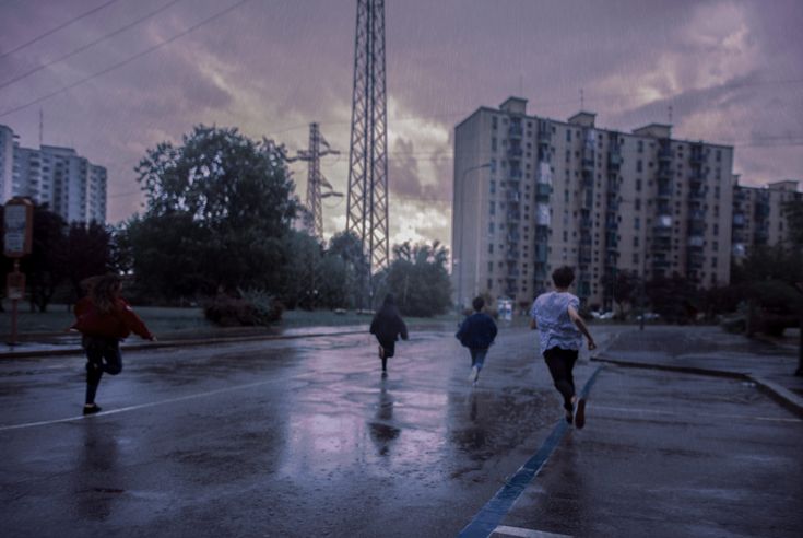 some people are walking down the street in the rain