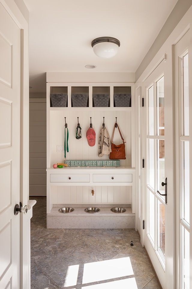 a kitchen with white cabinets and counter tops next to open doors that lead into another room