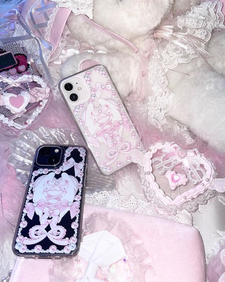 an iphone case sitting next to a teddy bear on a pink and white bed spread