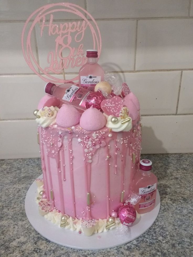 a birthday cake with pink frosting and decorations