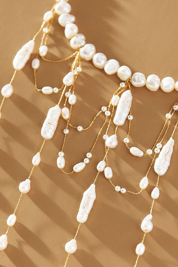 A stunning display of freshwater pearls, this choker necklace features a string of pearls that elegantly encircle the neck. Below, elongated droplets and draped strands intertwine gracefully, creating a lustrous and eye-catching statement piece. | Waterfall Pearl Choker Necklace by Anthropologie in Gold, Women's, Gold/Plated Brass/Freshwater Pearl Luxury Pearl Choker Necklace, Pearl Drop Necklace For Party, Luxury Pearl Drop Necklace For Wedding, Elegant Beaded Drop Necklace, Elegant Drop Necklace With Dangling Beads For Party, Pearl Necklace With Dangling Beads For Party, Elegant Pearl Necklace With Dangling Beads For Wedding, Lariat Pearl Necklace With Charm For Parties, Elegant Pearl Necklaces With Dangling Beads