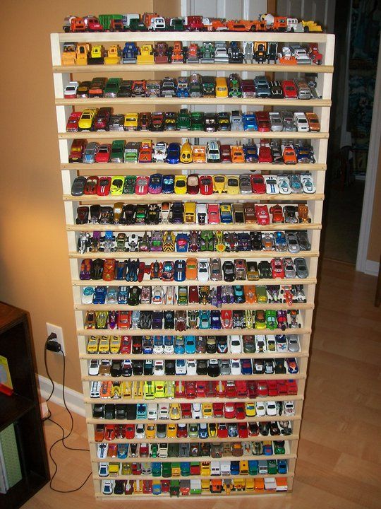 a wooden shelf filled with lots of toy cars