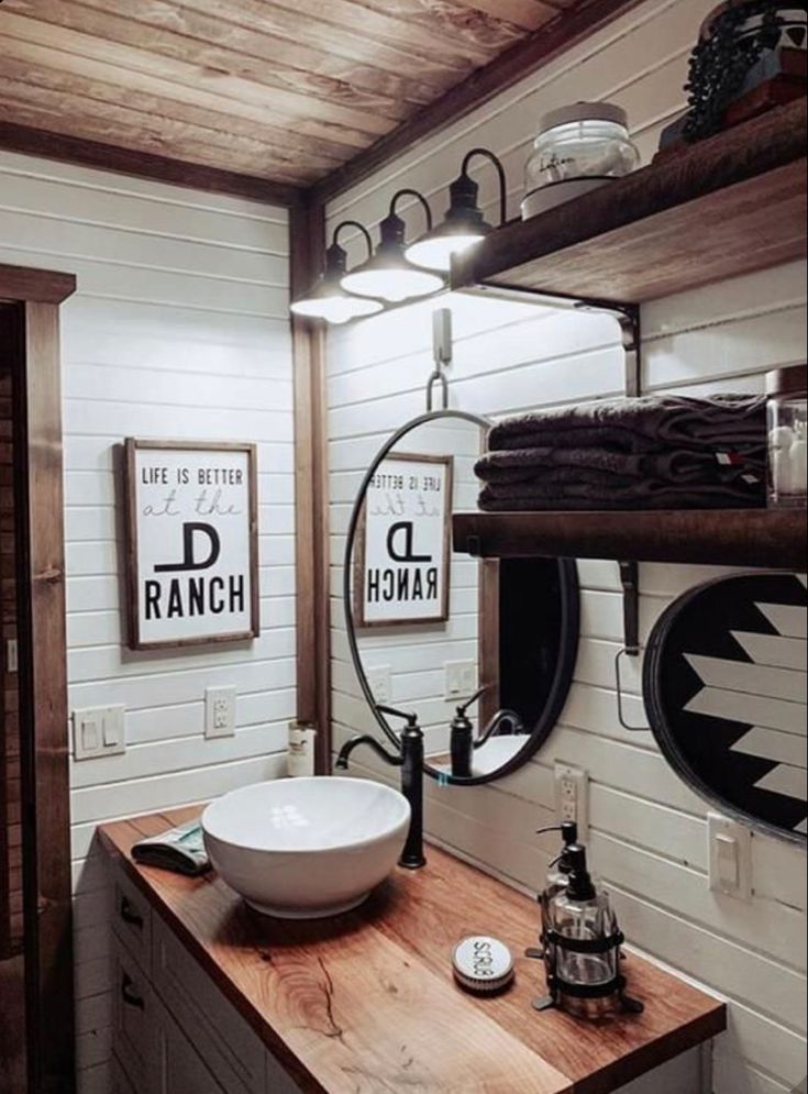 a bathroom with a sink, mirror and shelves on the wall next to each other