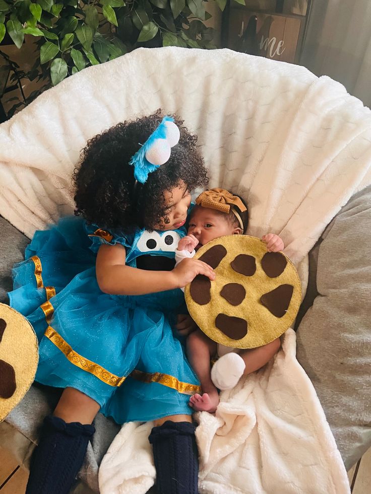 two children in costumes laying on a couch