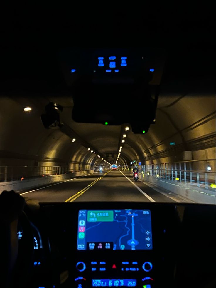 a car driving through a tunnel with lights on it's dash board and dashboard