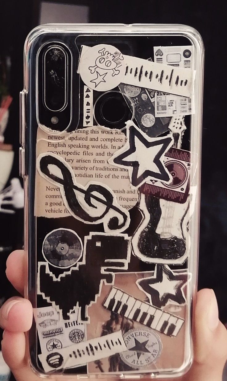 someone holding up their phone case with stickers on it