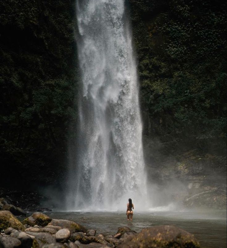 a person standing in front of a waterfall