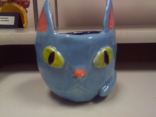 a blue ceramic cat mug with yellow eyes