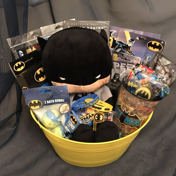 a batman themed gift basket on a bed