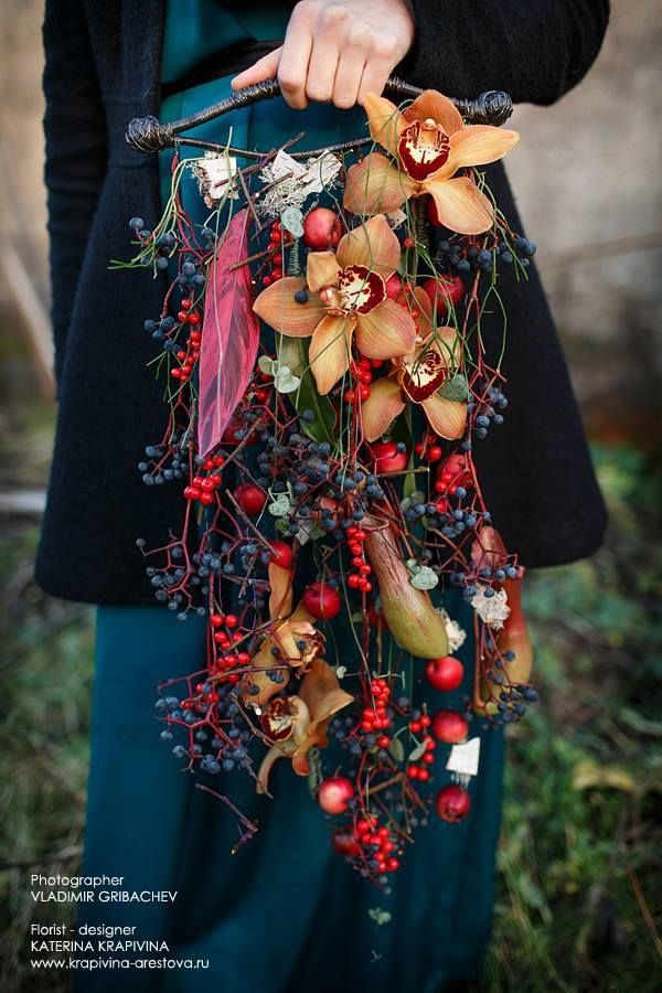 a woman holding a bouquet of flowers and berries in her hands with the caption's name on it