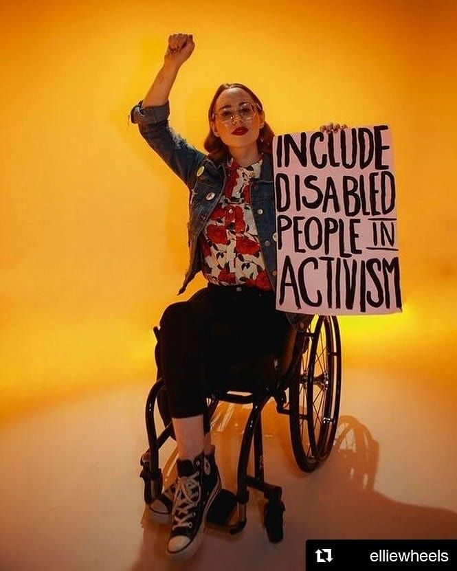 a woman sitting in a wheel chair holding a sign that reads include disabled people in activism