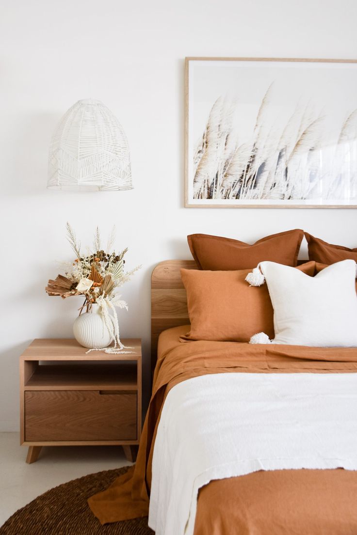 a bedroom with a bed, nightstands and pictures on the wall above it that is decorated in neutral colors