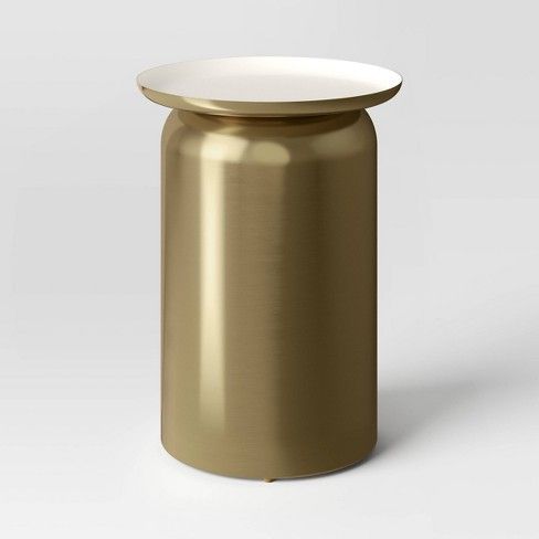 a gold metal canister with a white lid