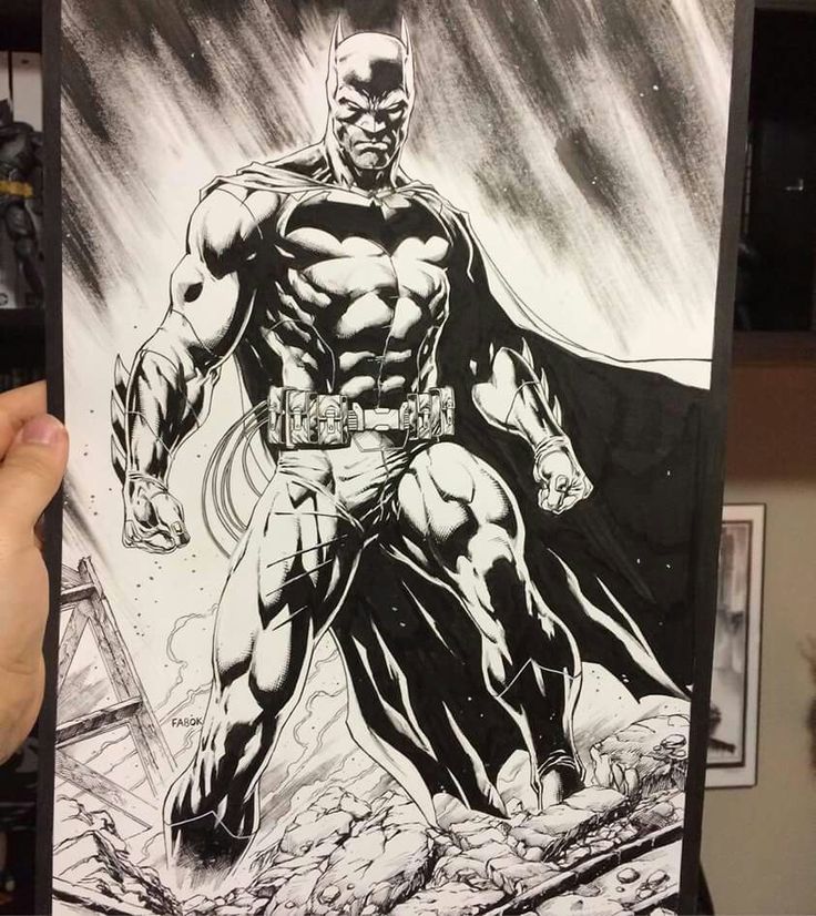 a person holding up a drawing of batman