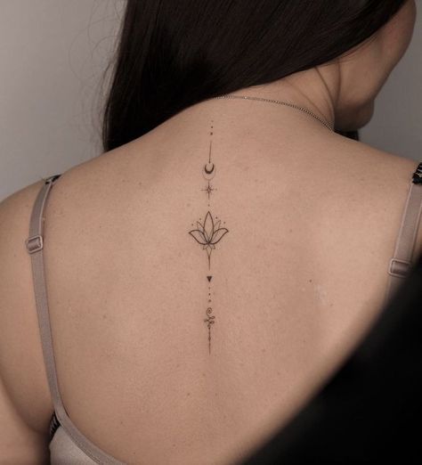 the back of a woman's neck with a flower tattoo on it