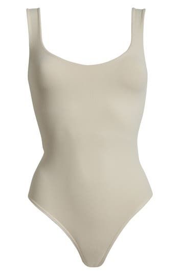 A sleek curve-hugging bodysuit featuring a dipped neckline and low U-back. Stretch fit Built-in shelf bra Snap gusset closure Thong cut 92% nylon, 8% elastane Machine wash, dry flat Imported Summer Elegant Bodysuit With Scoop Back, Elegant Summer Bodysuit With Scoop Back, Elegant High Cut Smoothing Bodysuit, Elegant High-cut Smoothing Bodysuit, Chic Seamless Second-skin Bodysuit, Elegant Second-skin Scoop Neck Bodysuit, Elegant Scoop Back Swimwear, Chic Fitted Smoothing Leotard, Chic Second-skin Leotard With Lined Body