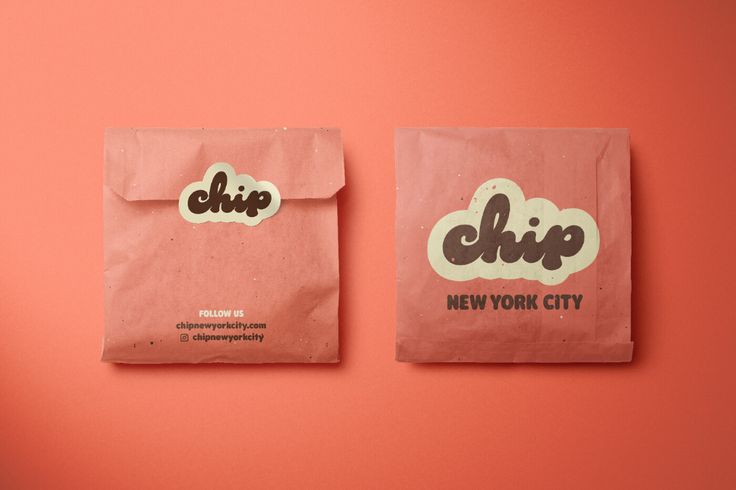 two bags with stickers on them sitting next to each other in front of a pink wall