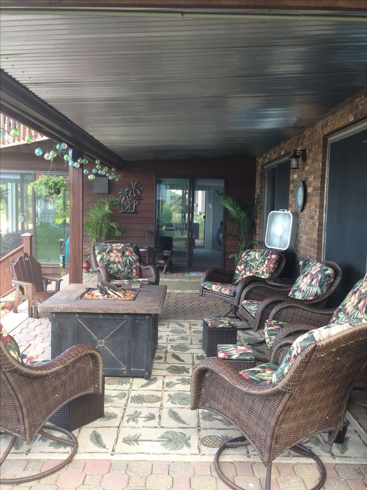 an outdoor patio with wicker furniture and brick flooring