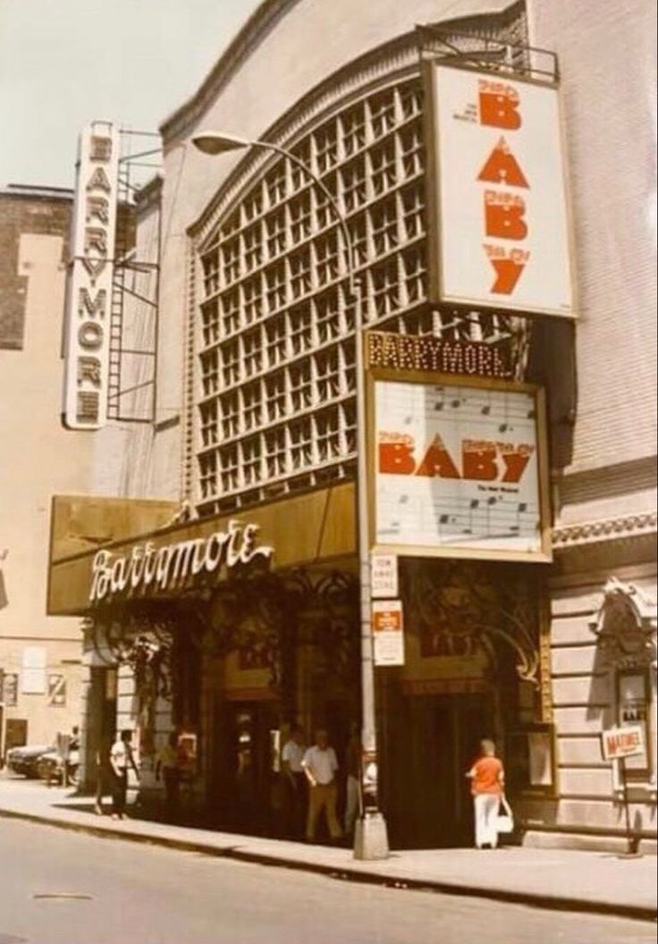 an old photo of the front of a building with people standing outside and looking at it