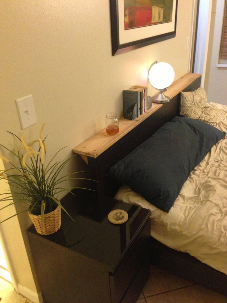 a bedroom with a bed, night stand and potted plant on the side table