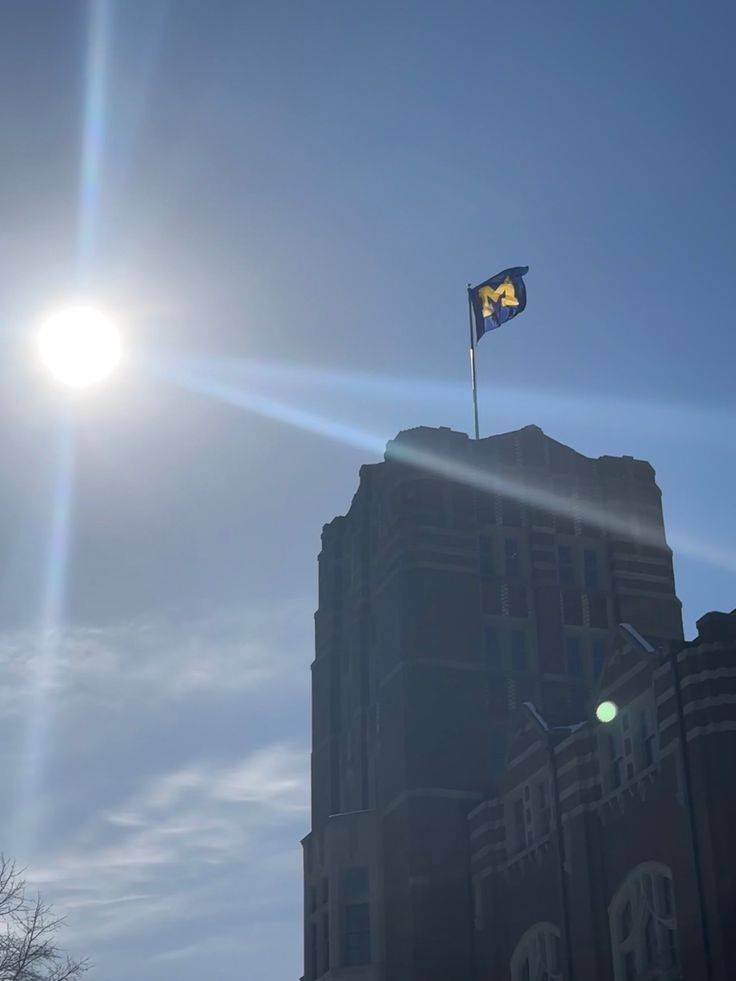 the sun shines brightly over a building with a flag on it's roof