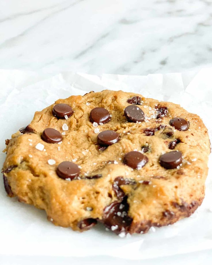 a chocolate chip cookie sitting on top of white paper