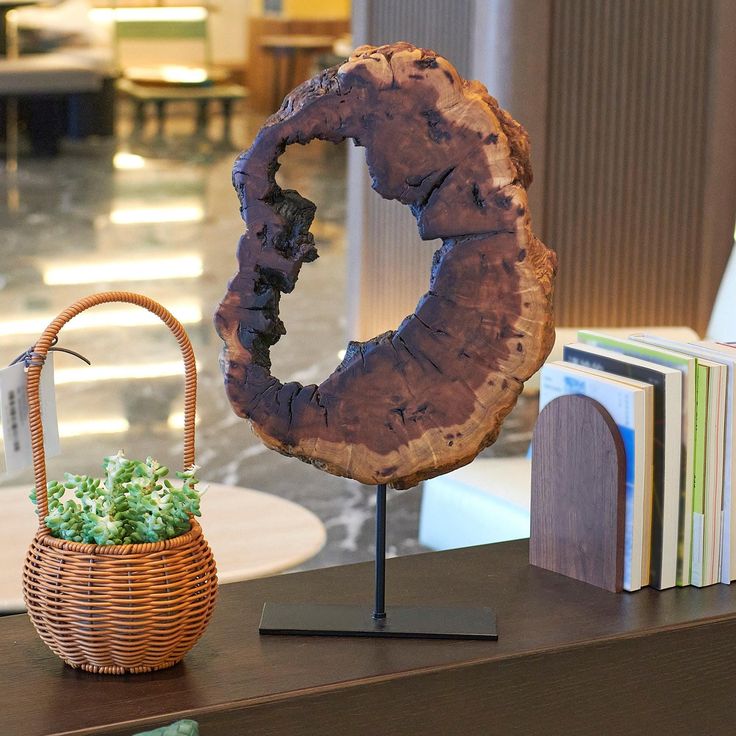 a wooden object sitting on top of a table next to a basket filled with books