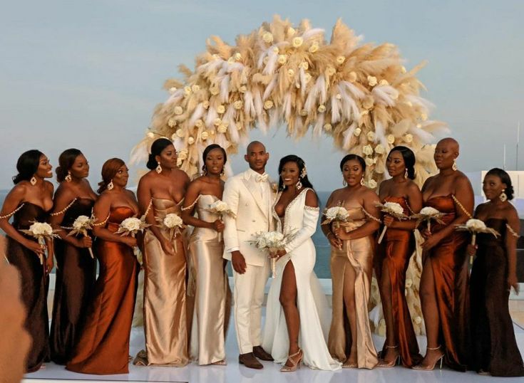 a group of women standing next to each other in front of a white and gold arch