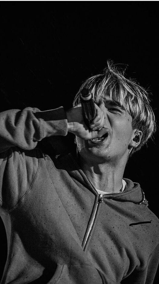 a young man making a face while holding his hand to his ear