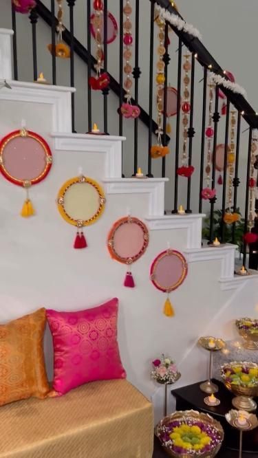 a living room filled with lots of furniture next to a stair case covered in mirrors