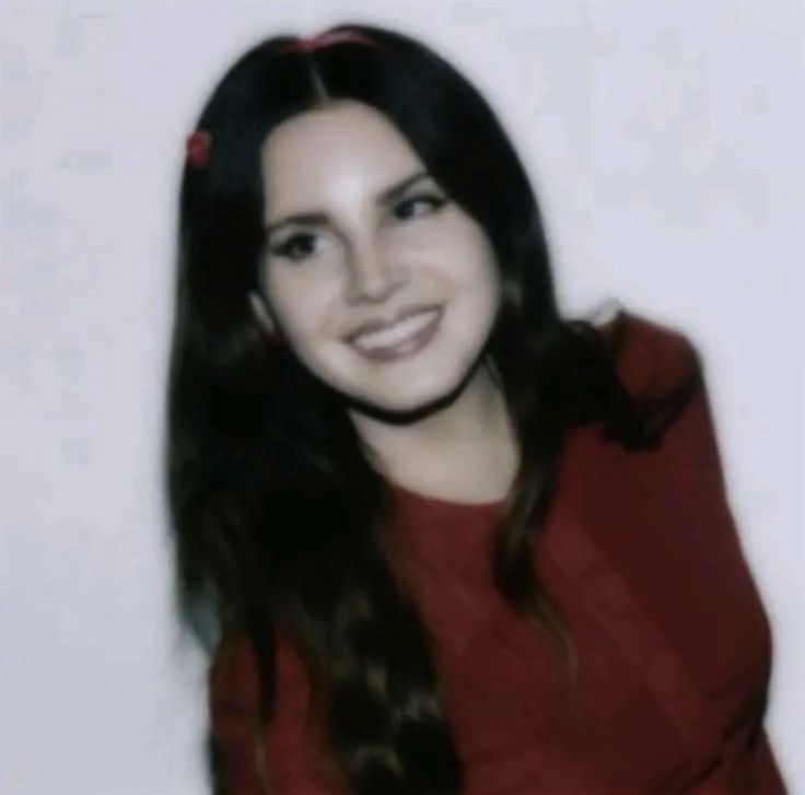 a woman with long dark hair wearing a red shirt