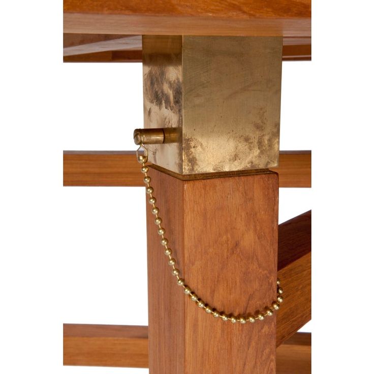 a close up of a wooden table with a chain on the end and a piece of wood in front of it