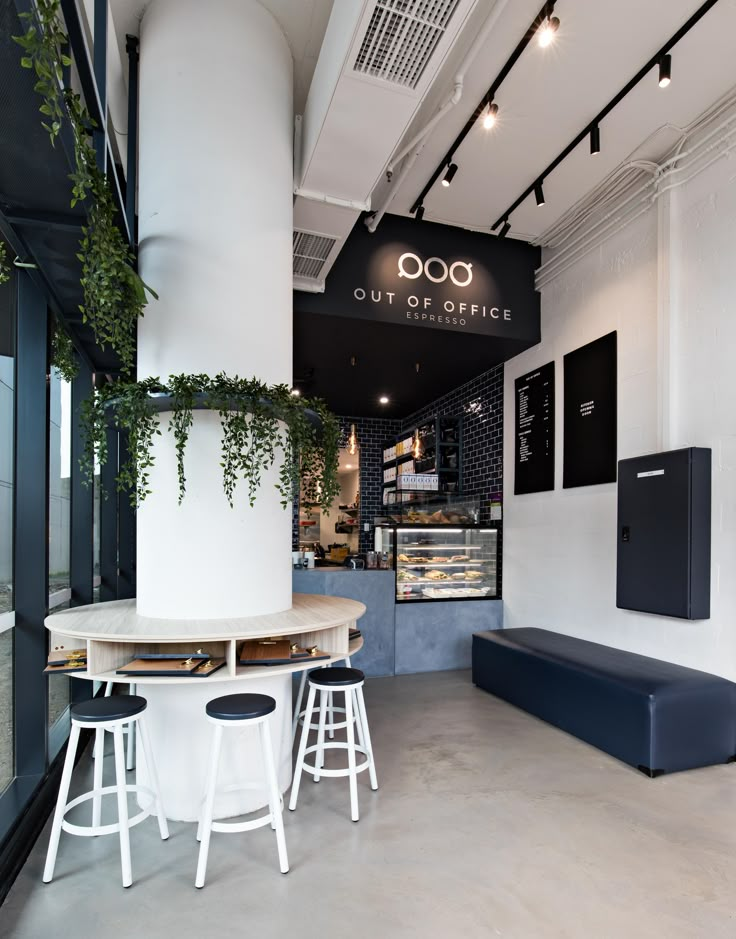 the interior of a coffee shop with stools and tables