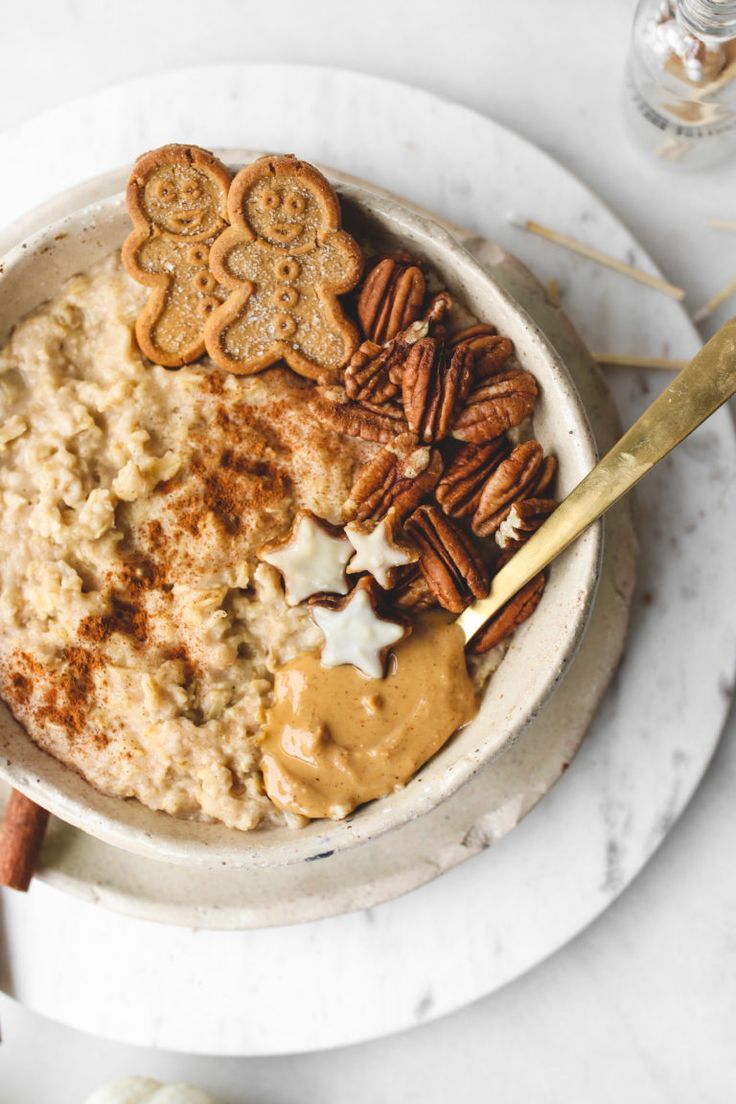 a bowl filled with oatmeal topped with pecans and star shaped cookies