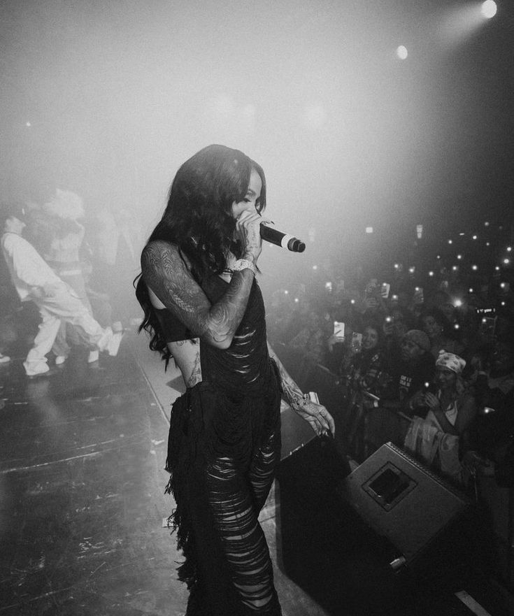 black and white photograph of a woman singing into a microphone in front of an audience