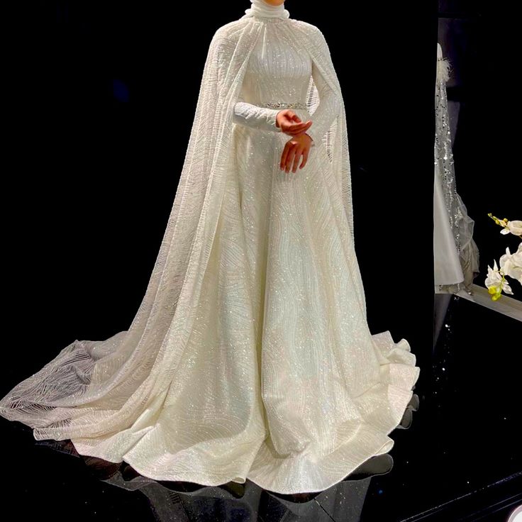 a mannequin dressed in a white gown and cape